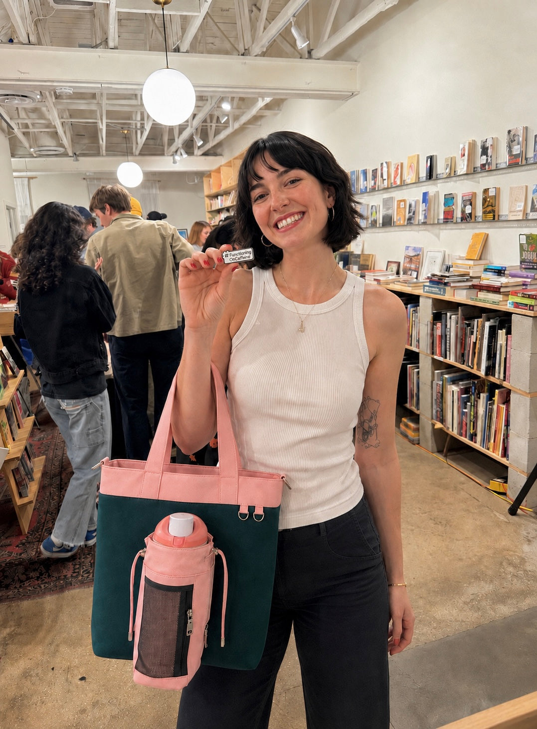 Woman carrying pink and green water bottle tote bag while shopping