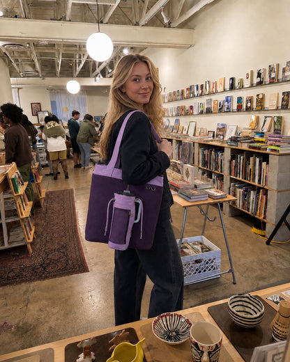 Woman carrying a purple water bottle tote bag while shopping