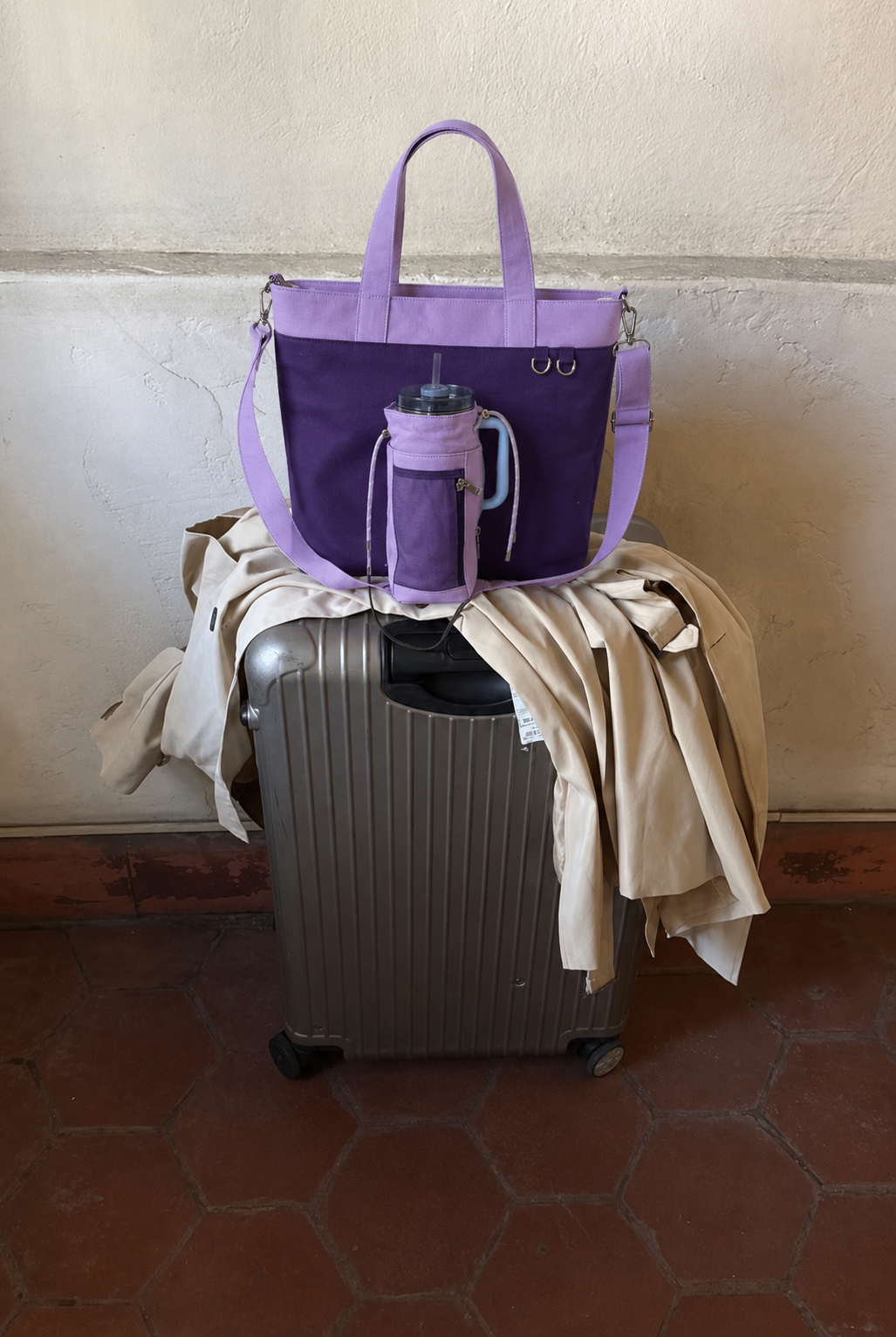 Purple water bottle tote bag with dedicated bottle holder on suitcase